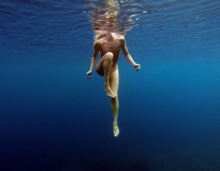 Naked women jump in water