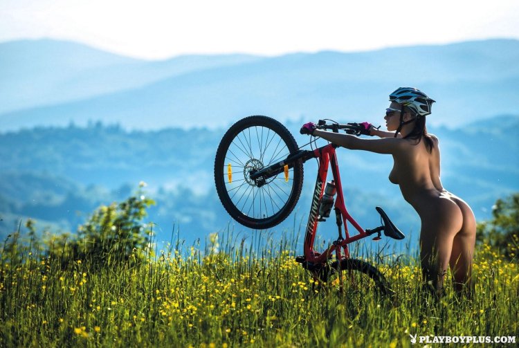 Naked Jenny Gregg on a bicycle