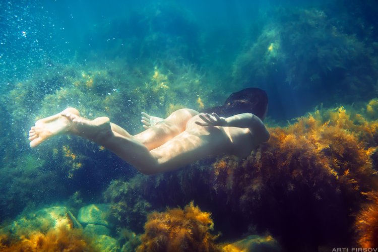 Naked mermaids under water